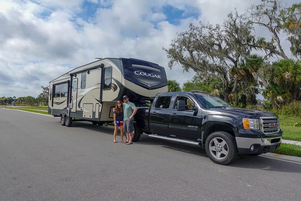 Full-Time RVers Cindy and Barrett standing in front of their RV