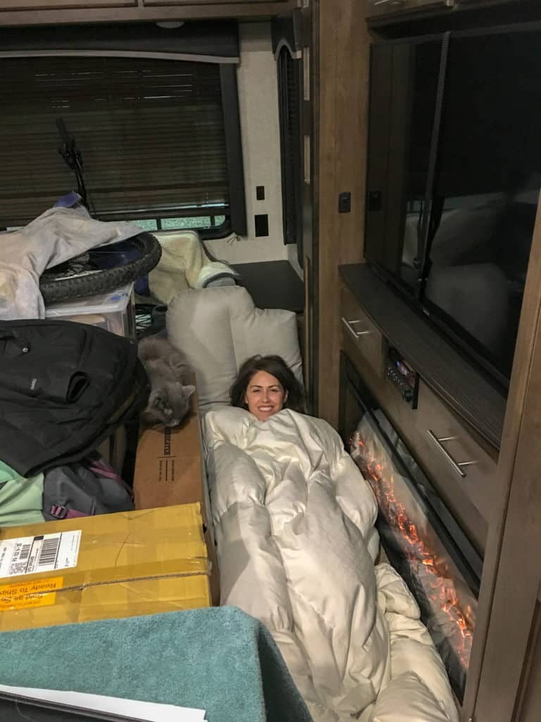 Staying warm was a difficult part of adjusting to RV life, Cindy laying by the electric fireplace because we ran out of propane