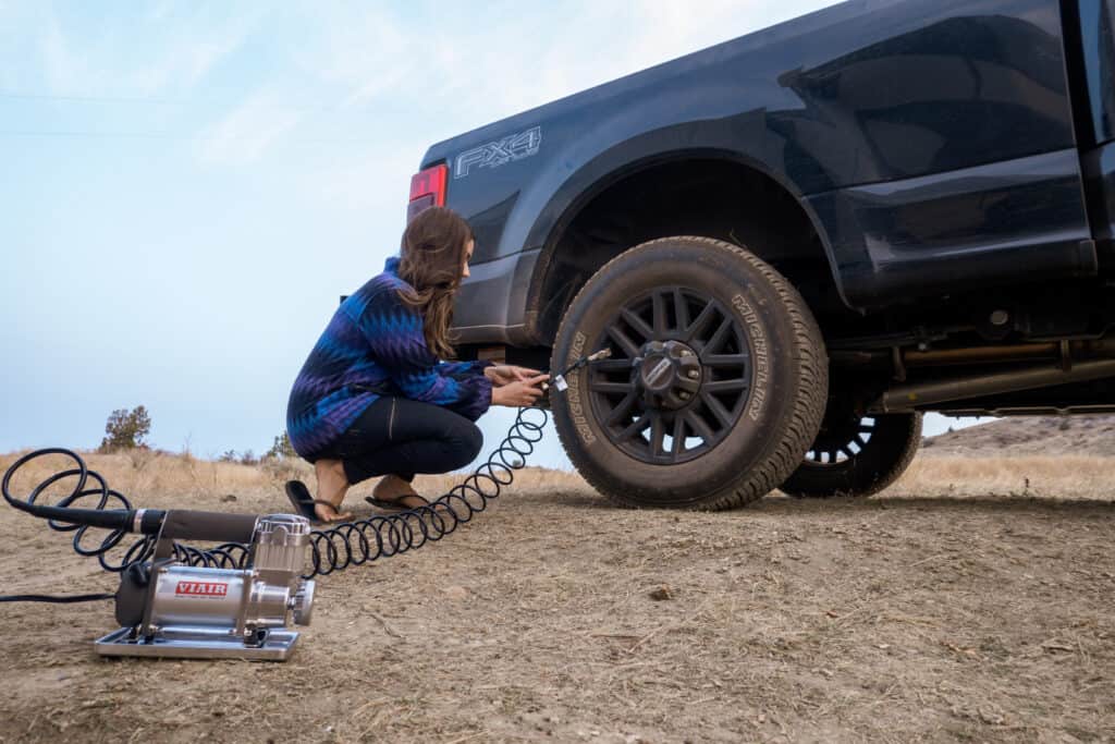 Cindy using one of the RV must-haves, the Viair Tire Compressor