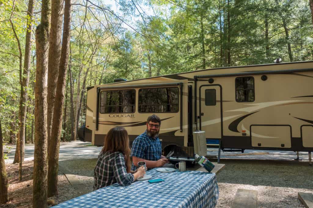 RV must-haves Cindy and Barrett grilling at a campsite