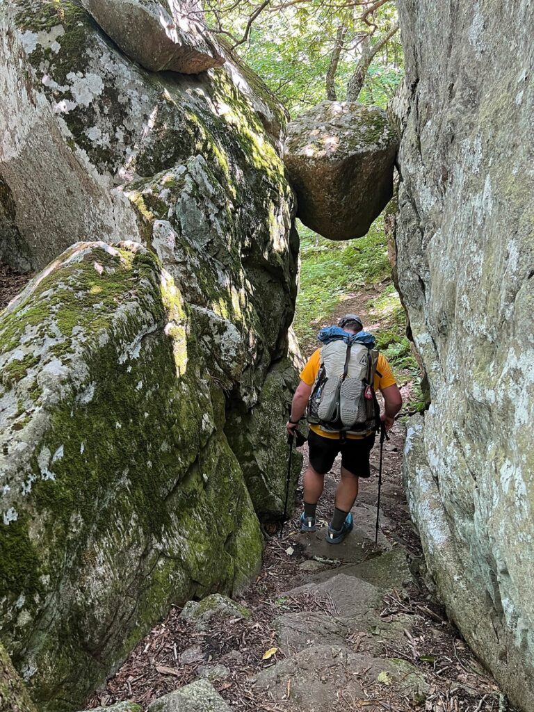 Appalachian Trail Journal Week 13: 800 Miles, Virginia Views & Big Decisions 16 IMG 0512 Barrett hiking under suspended rock on AT